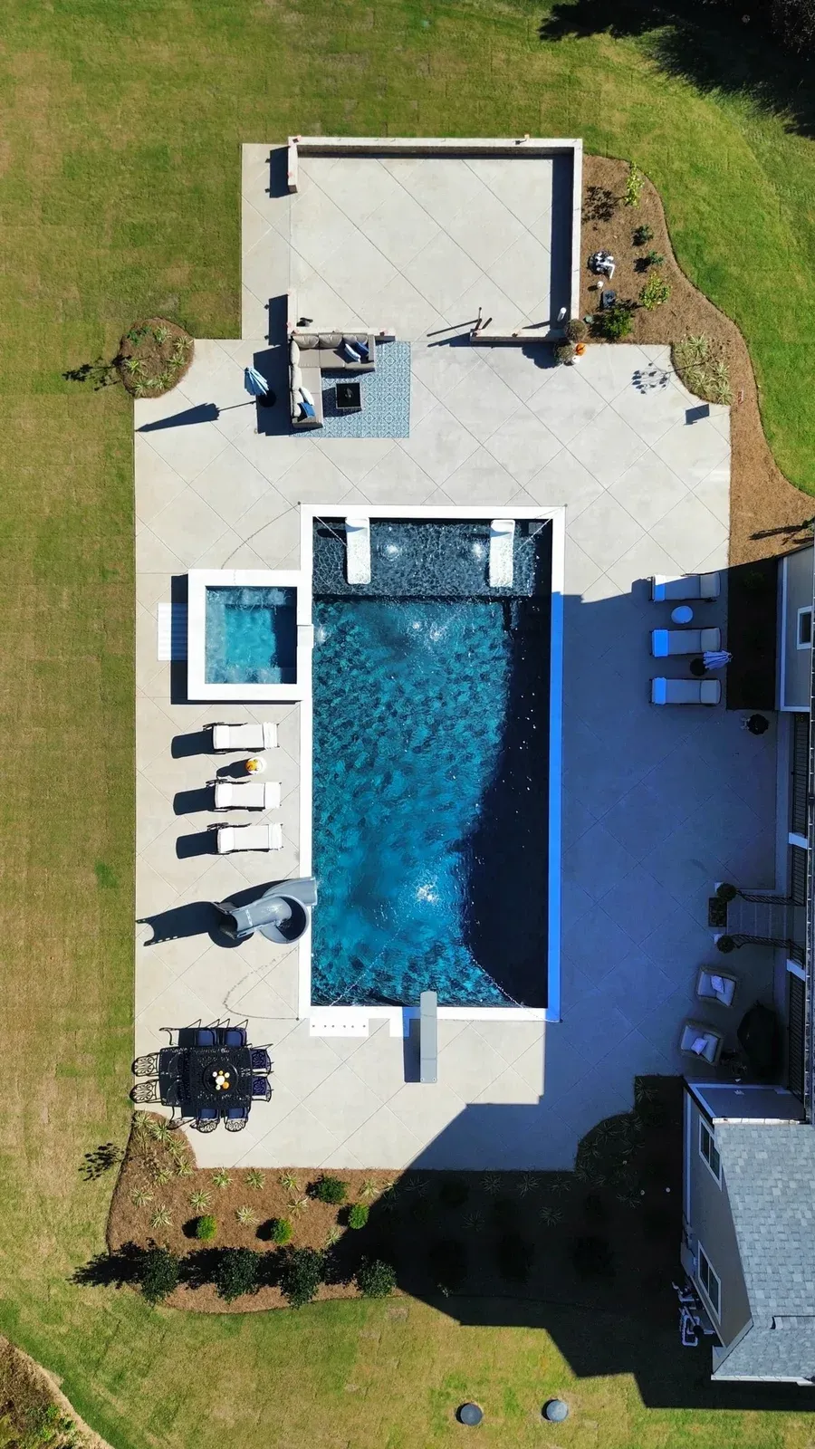 Clayton Inground Pool, Black Slate and Granite Grey Membrane with Ice White Travertine and Brushed Concrete Patio